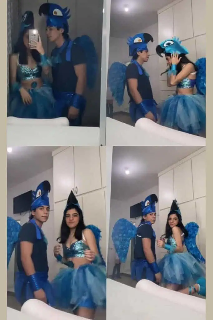 Couple dressed in blue Rio bird Halloween costumes inspired by the animated movie. Outfits feature feathered wings, bird headpieces, blue tutus, and sparkly tops for a fun and creative couples costume idea.