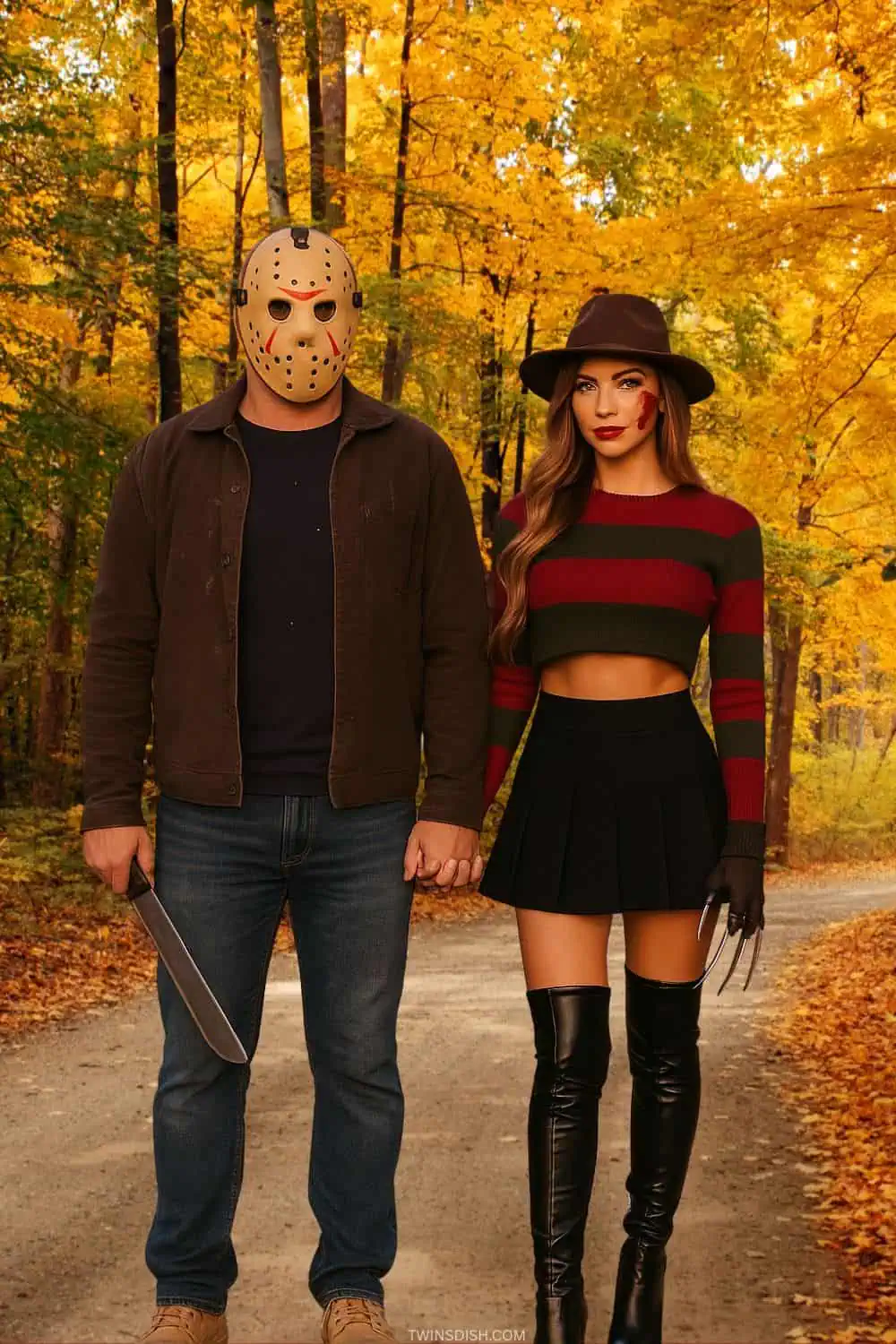 Couple in Jason Voorhees and female Freddy Krueger Halloween costumes holding hands on a fall path with autumn leaves.